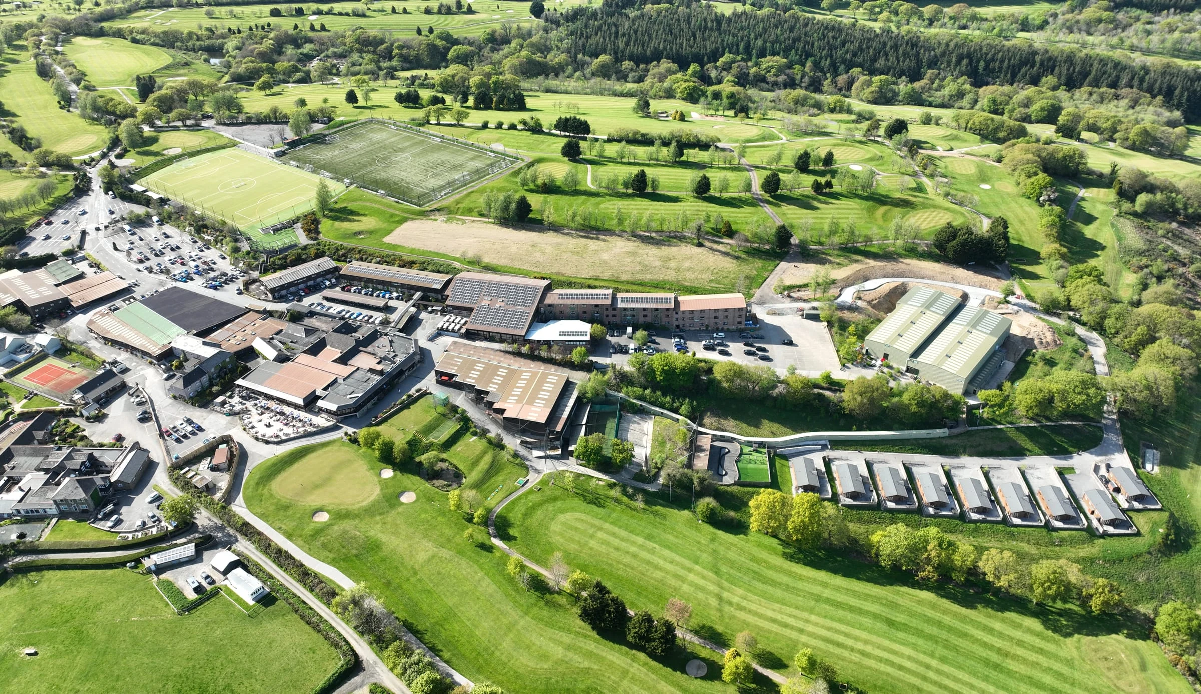 Aerial view of the Ashbury Resort: the hotel, sports pitches, golf course and lodges in the Devon countryside