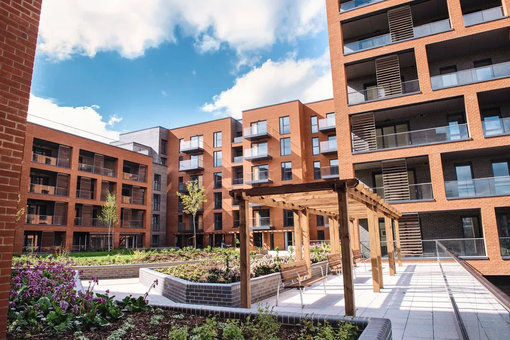 The landscaped courtyard at Halton Court, Kidbrooke, with a timber pergola and balconies above